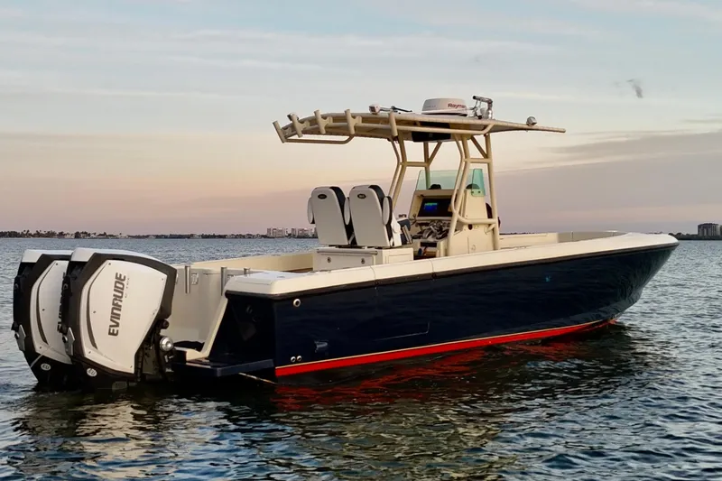 The Image of 2003 Intrepid 289 Center Console boat on calm water at sunset. - 0