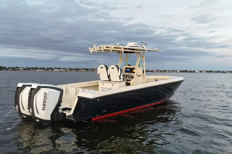 Slide: The Image of 2003 Intrepid 289 Center Console boat on water with dual Evinrude engines. - 11