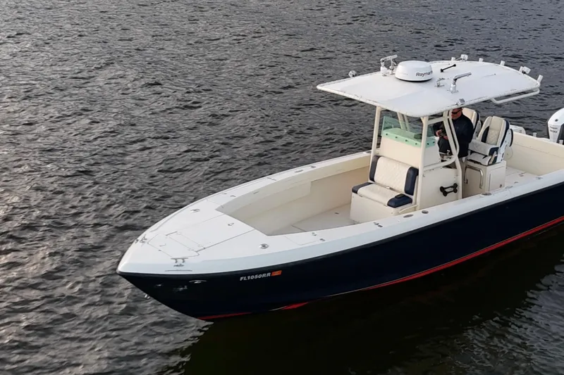 Slide: The Image of 2003 Intrepid 289 Center Console boat on water, featuring sleek design and spacious deck. - 15