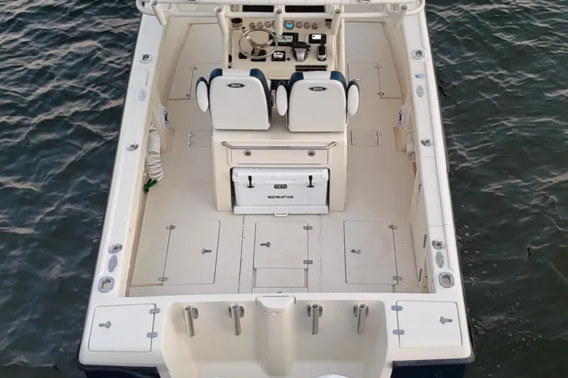 Slide: The Image of 2003 Intrepid 289 Center Console boat on water, featuring spacious deck and dual seating. - 19