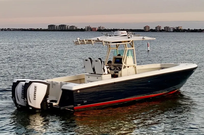 Slide: The Image of 2003 Intrepid 289 Center Console boat on calm water at sunset. - 2