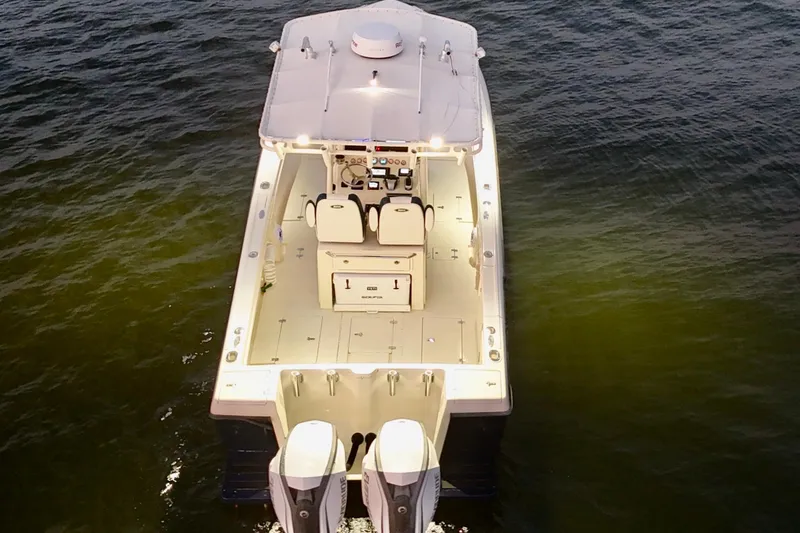 Slide: The Image of 2003 Intrepid 289 Center Console boat on water, aerial view, illuminated deck. - 21