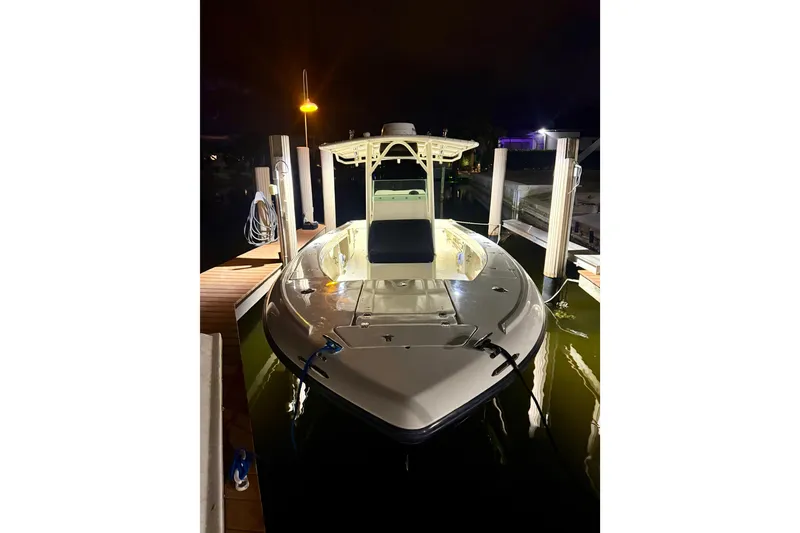 Slide: The Image of 2003 Intrepid 289 Center Console boat docked at night, illuminated by lights. - 26