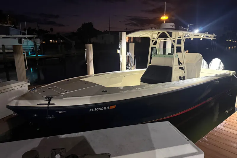 Slide: The Image of 2003 Intrepid 289 Center Console boat docked at night with lights on. - 27