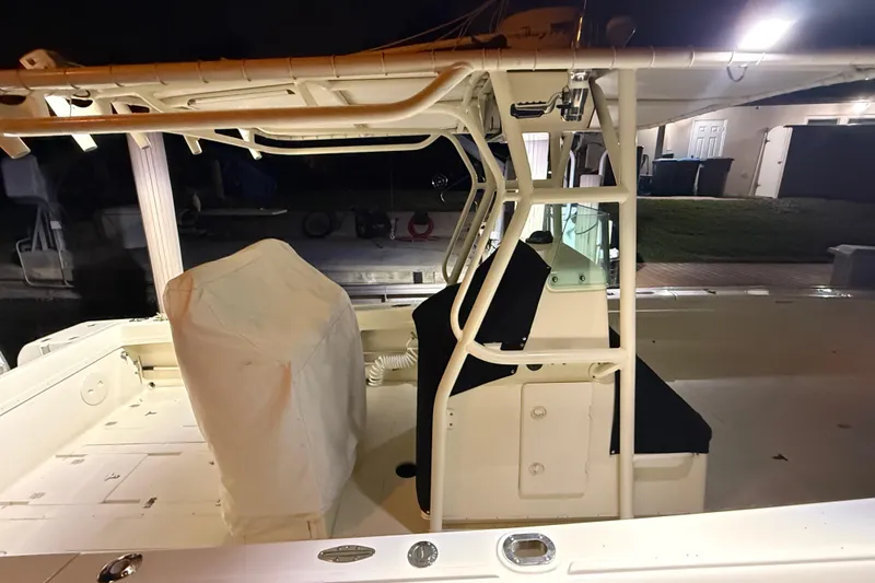 Slide: The Image of 2003 Intrepid 289 Center Console boat interior at night, featuring covered seating and console. - 30
