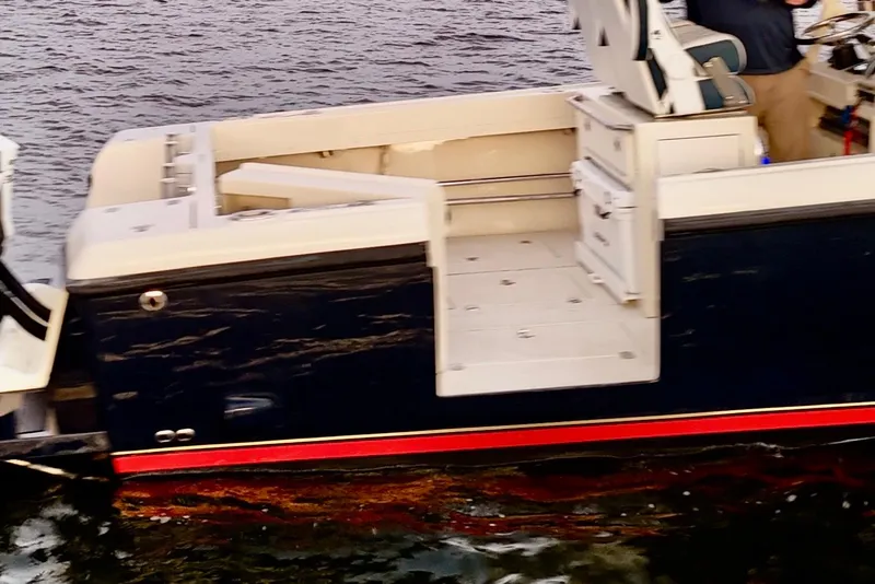 Slide: The Image of 2003 Intrepid 289 Center Console boat on water, featuring sleek design and spacious seating. - 33