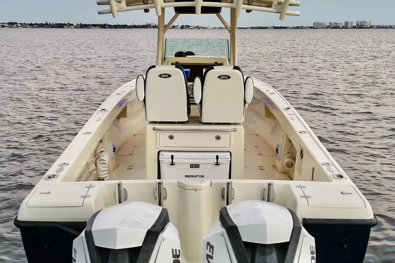 Slide: The Image of 2003 Intrepid 289 Center Console boat on water, featuring dual engines and spacious deck. - 36
