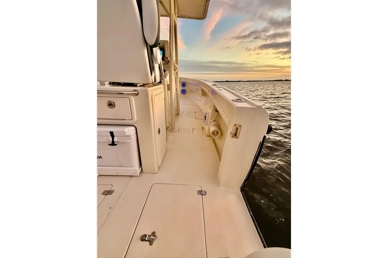 Slide: The Image of 2003 Intrepid 289 Center Console boat on water at sunset, showcasing deck and storage. - 43