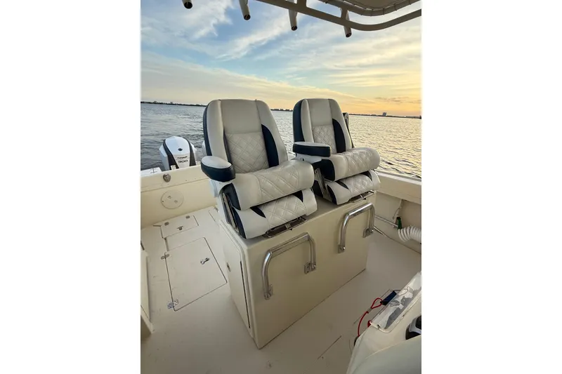 Slide: The Image of 2003 Intrepid 289 Center Console boat interior with dual seats, ocean view at sunset. - 45