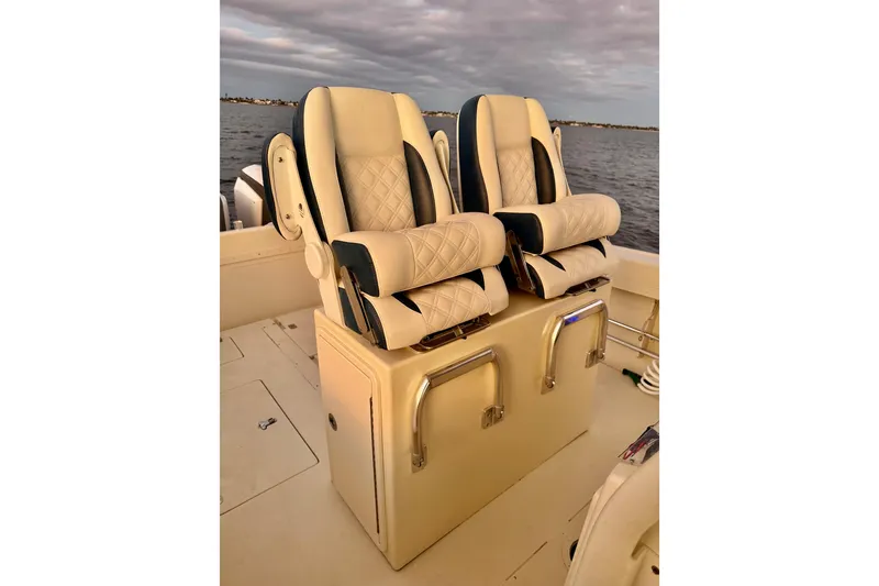 Slide: The Image of 2003 Intrepid 289 Center Console boat seats with quilted upholstery on calm water. - 48