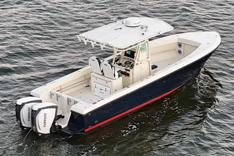 Slide: The Image of 2003 Intrepid 289 Center Console boat on water, featuring dual Evinrude engines. - 5