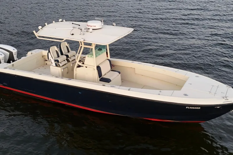 Slide: The Image of 2003 Intrepid 289 Center Console boat on water, featuring sleek design and spacious deck. - 6