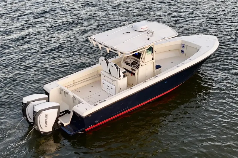 Slide: The Image of 2003 Intrepid 289 Center Console boat on water, featuring dual Evinrude engines. - 7