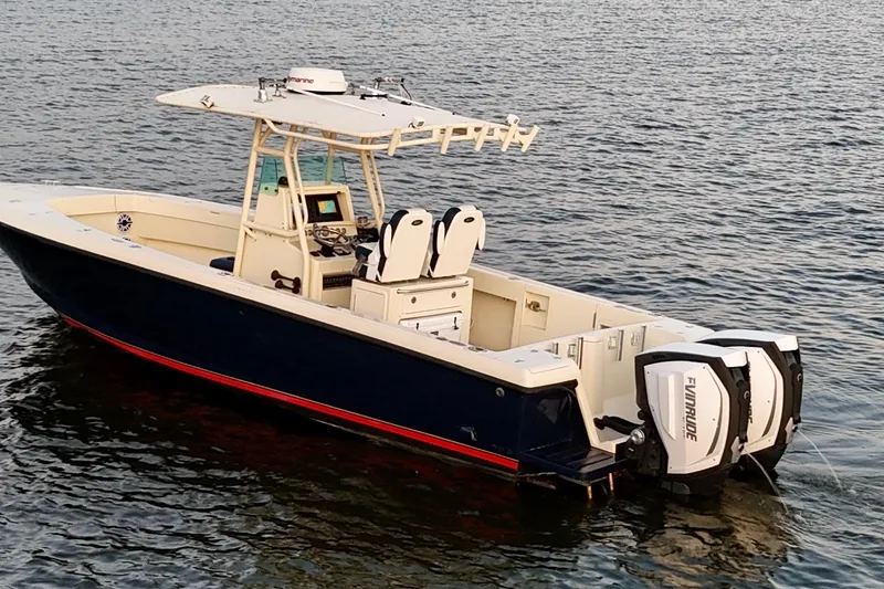 Slide: The Image of 2003 Intrepid 289 Center Console boat on water, featuring dual Evinrude engines. - 8
