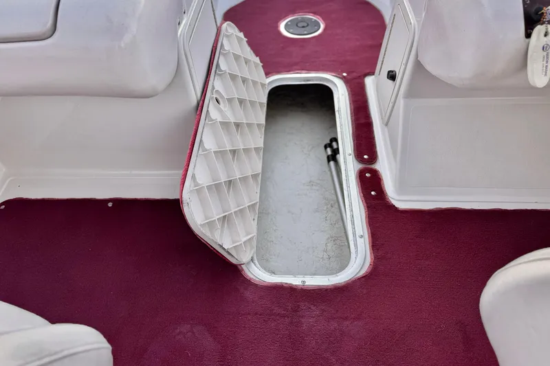Slide: The Image of Open storage compartment on 2000 Godfrey Hurricane 2100 Sundeck boat with maroon carpet. - 15