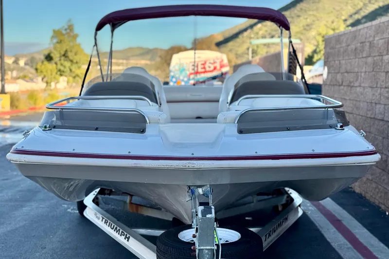 Slide: The Image of 2000 Godfrey Hurricane 2100 Sundeck boat on trailer, parked outdoors. - 2