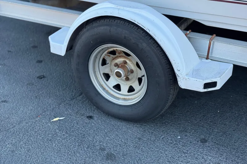 Slide: The Image of Trailer wheel of a 2000 Godfrey Hurricane 2100 Sundeck on asphalt surface. - 21