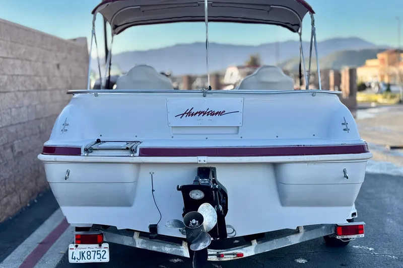 Slide: The Image of 2000 Godfrey Hurricane 2100 Sundeck boat, rear view with trailer, parked outdoors. - 4