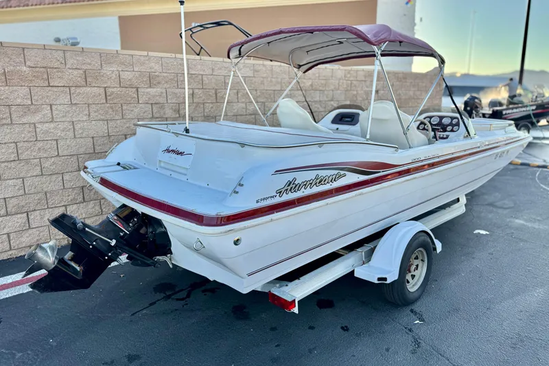 Slide: The Image of 2000 Godfrey Hurricane 2100 Sundeck boat on trailer, parked outdoors. - 5