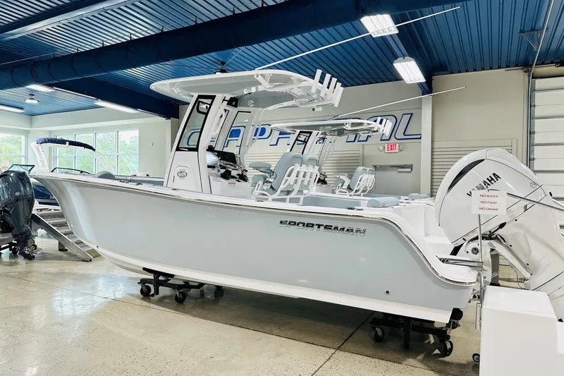 The Image of 2026 Sportsman Open 232 Center Console boat displayed indoors with Yamaha engine. - 2
