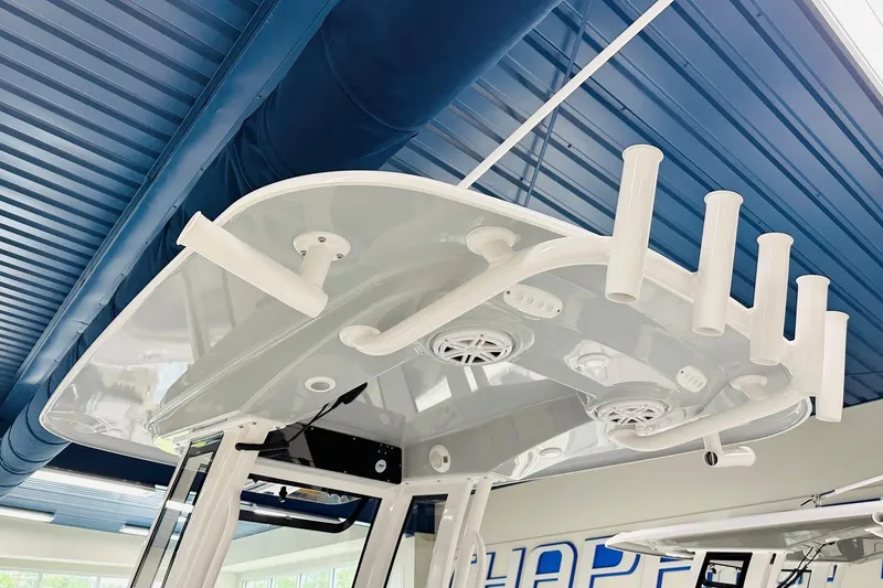 Slide: The Image of 2026 Sportsman Open 232 Center Console boat's T-top with rod holders and speakers. - 7