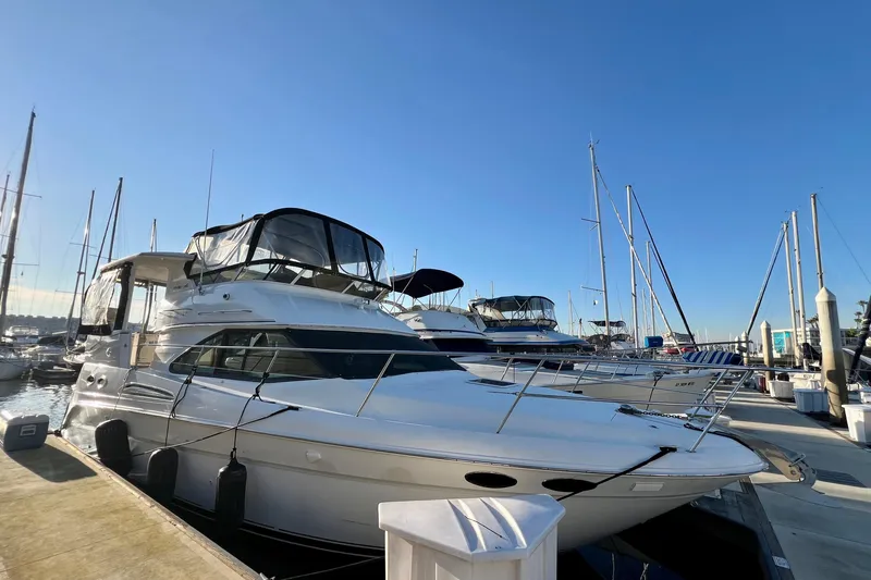The Image of 1997 Sea Ray 370 Aft Cabin yacht docked at marina under clear blue sky. - 1