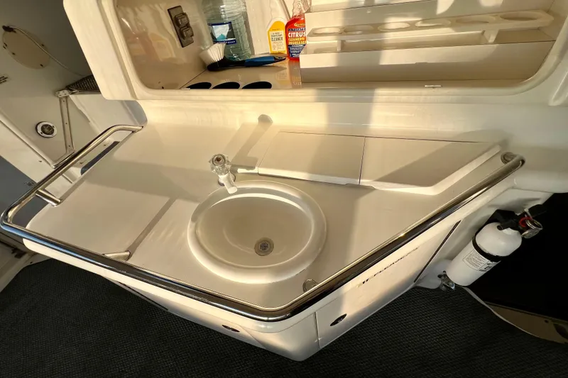 Slide: The Image of 1997 Sea Ray 370 Aft Cabin boat sink area with faucet and storage. - 16