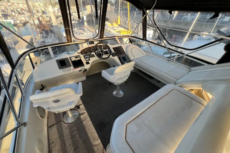 Slide: The Image of 1997 Sea Ray 370 Aft Cabin helm with dual seats and panoramic marina view. - 21