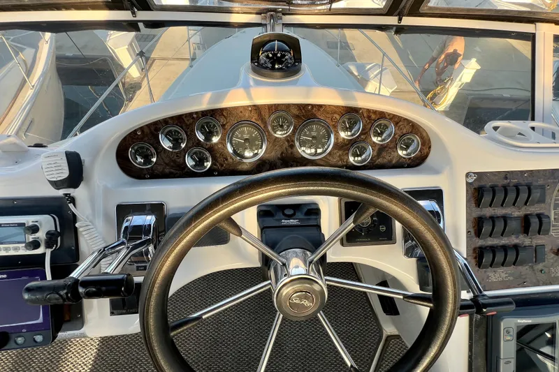 Slide: The Image of 1997 Sea Ray 370 Aft Cabin helm with gauges, steering wheel, and controls. - 25