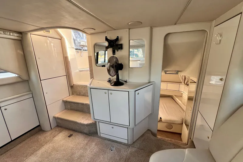 Slide: The Image of 1997 Sea Ray 370 Aft Cabin interior with white cabinetry and cozy sleeping area. - 33