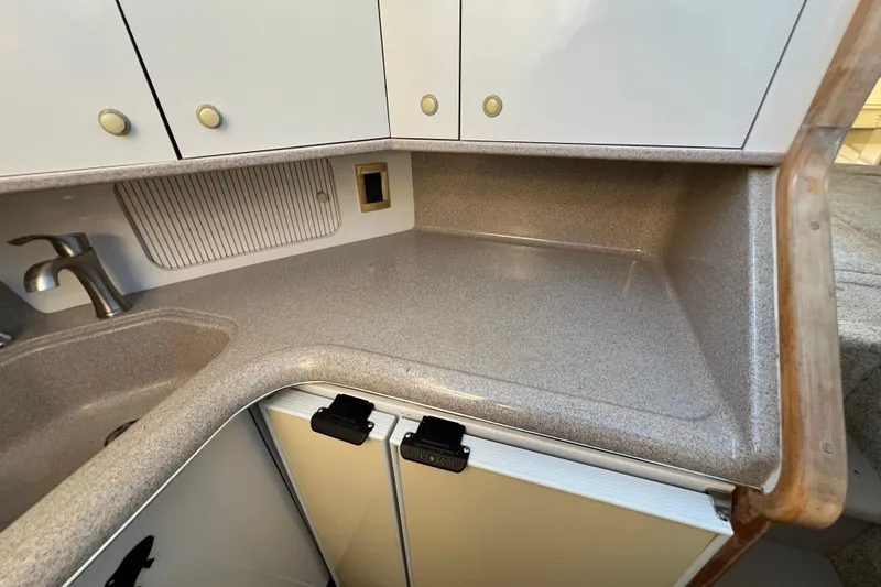 Slide: The Image of 1997 Sea Ray 370 Aft Cabin kitchen with countertop, sink, and cabinets. - 42