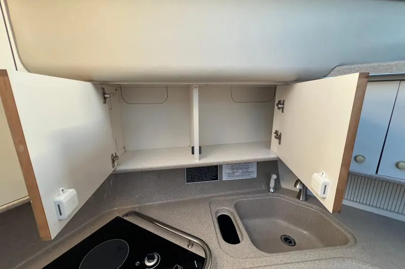 Slide: The Image of 1997 Sea Ray 370 Aft Cabin kitchen with open cabinets and sink. - 44