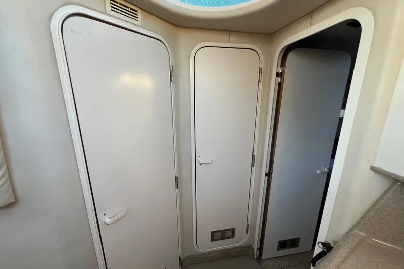Slide: The Image of Interior view of 1997 Sea Ray 370 Aft Cabin with three white doors. - 48