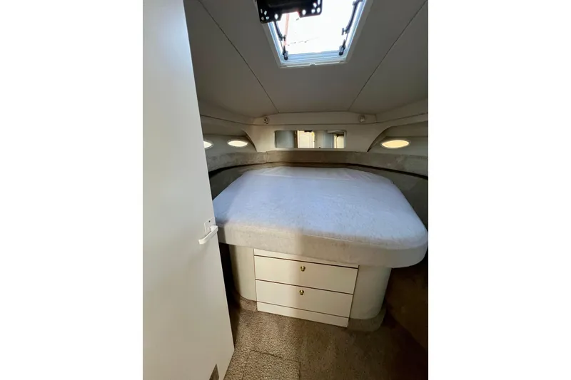 Slide: The Image of 1997 Sea Ray 370 Aft Cabin bedroom with bed, drawers, and overhead hatch. - 49