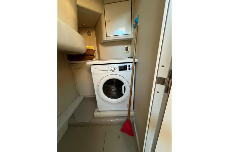 Slide: The Image of Laundry area in 1997 Sea Ray 370 Aft Cabin with washing machine and broom. - 58