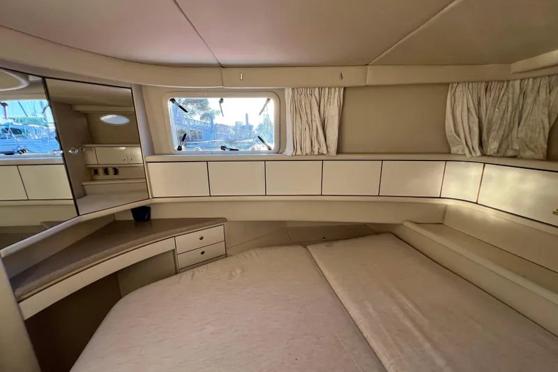 Slide: The Image of 1997 Sea Ray 370 Aft Cabin interior with bed, storage, and window view. - 67