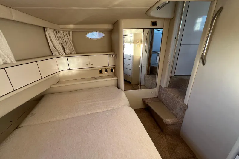 Slide: The Image of 1997 Sea Ray 370 Aft Cabin interior with bed, mirror, and storage cabinets. - 69