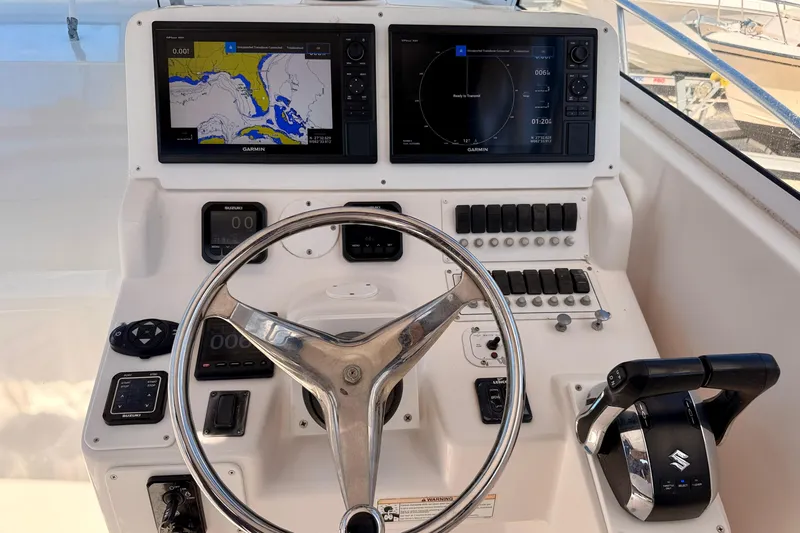 Slide: The Image of 2007 Pro-Line 32 Express helm with Garmin navigation displays and Suzuki controls. - 12