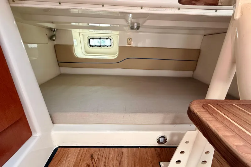 Slide: The Image of 2007 Pro-Line 32 Express cabin interior with bed and window, featuring wood accents. - 27