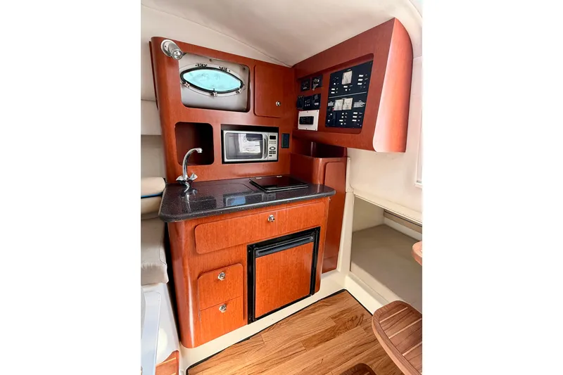 Slide: The Image of 2007 Pro-Line 32 Express boat interior with kitchenette, microwave, and control panel. - 29