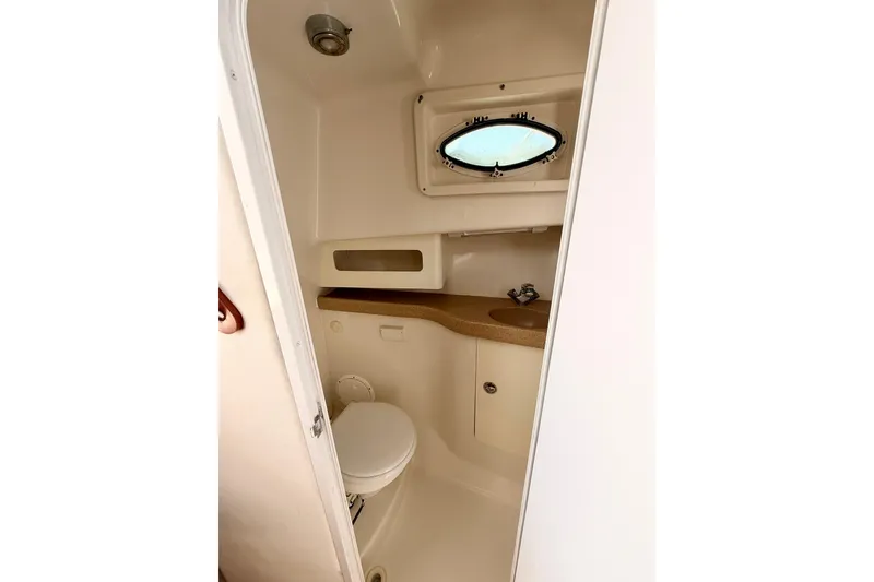 Slide: The Image of 2007 Pro-Line 32 Express boat bathroom with sink, toilet, and porthole window. - 31