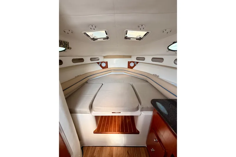 Slide: The Image of 2007 Pro-Line 32 Express cabin interior with cozy bed and wooden accents. - 33