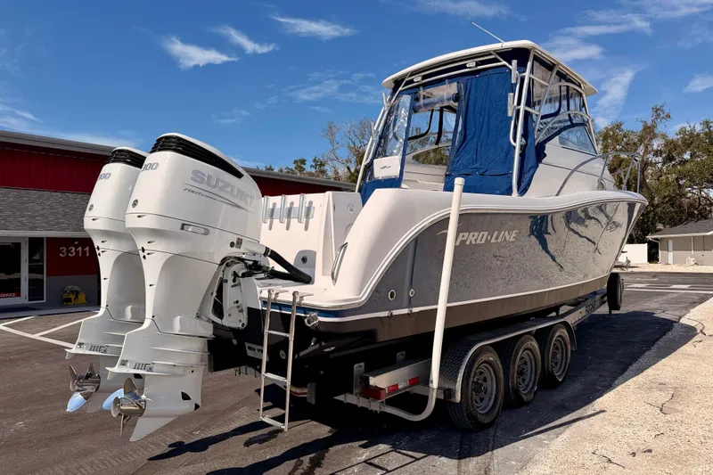 Slide: The Image of 2007 Pro-Line 32 Express boat with twin Suzuki outboard engines on a trailer. - 4