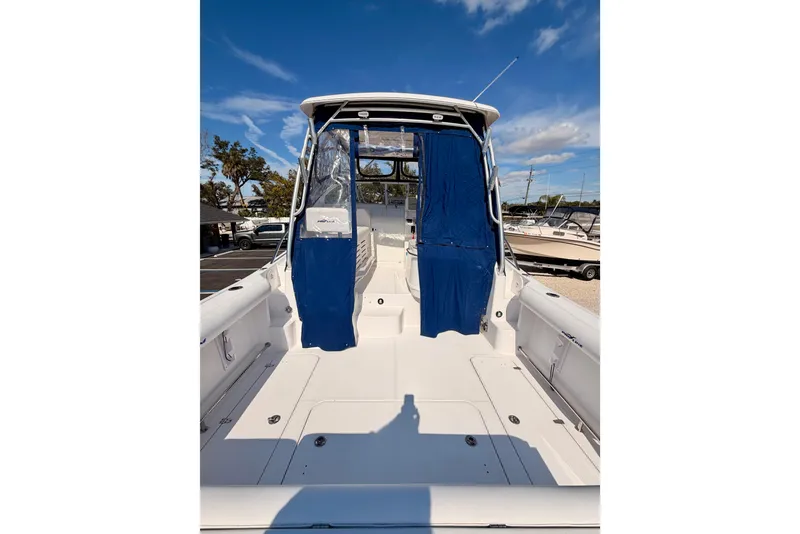 Slide: The Image of 2007 Pro-Line 32 Express boat with blue canopy, docked under clear sky. - 7