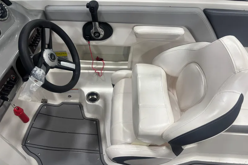 Slide: The Image of Interior of 2021 Chaparral 23 SSi boat with steering wheel and white captain's seat. - 18