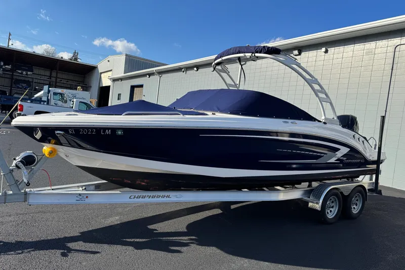 The Image of 2022 Chaparral 23 SSi OB boat on trailer, parked outdoors, under clear blue sky. - 0
