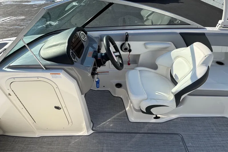 Slide: The Image of 2022 Chaparral 23 SSi OB boat interior with steering wheel and white seating. - 7