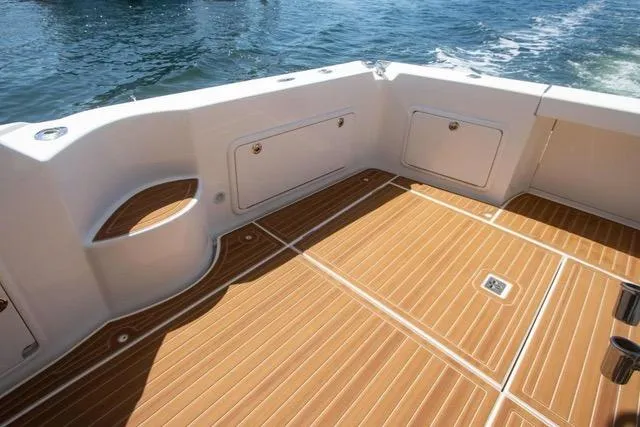Slide: The Image of 2003 Riviera 4700 Sport Yacht deck with teak flooring and storage compartments. - 14