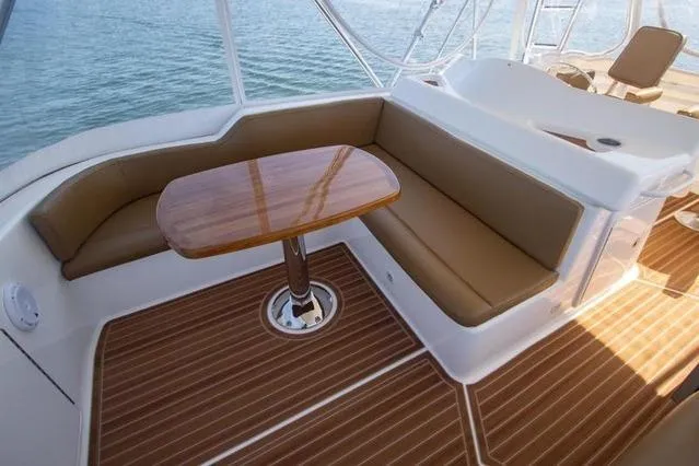 Slide: The Image of Luxurious seating area on 2003 Riviera 4700 Sport Yacht with wooden table and ocean view. - 25