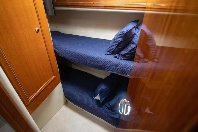 Slide: The Image of Bunk beds in 2003 Riviera 4700 Sport Yacht cabin with blue bedding. - 39